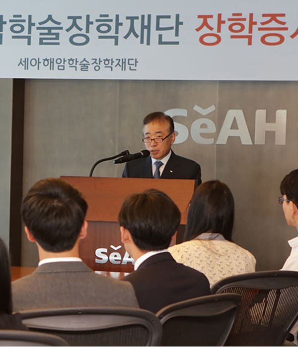 The back view of a man presenting and the audience.