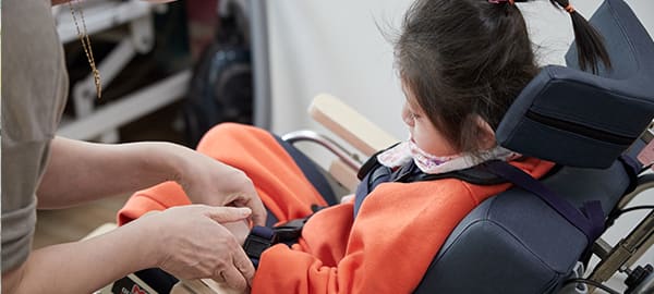 A child is sitting on a chair and undergoing an examination.